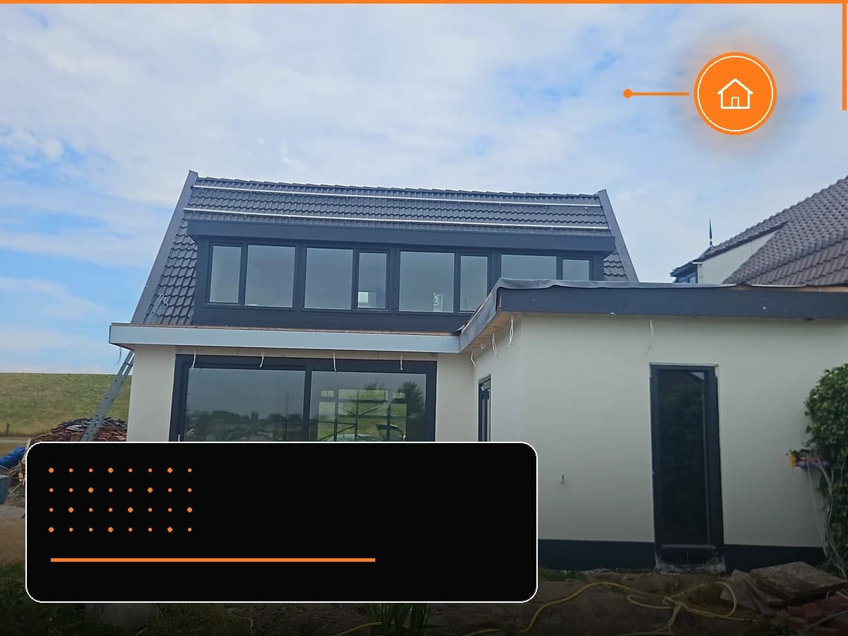 Aanbouw met grote glazen puntgevel aan de achterzijde van een woning